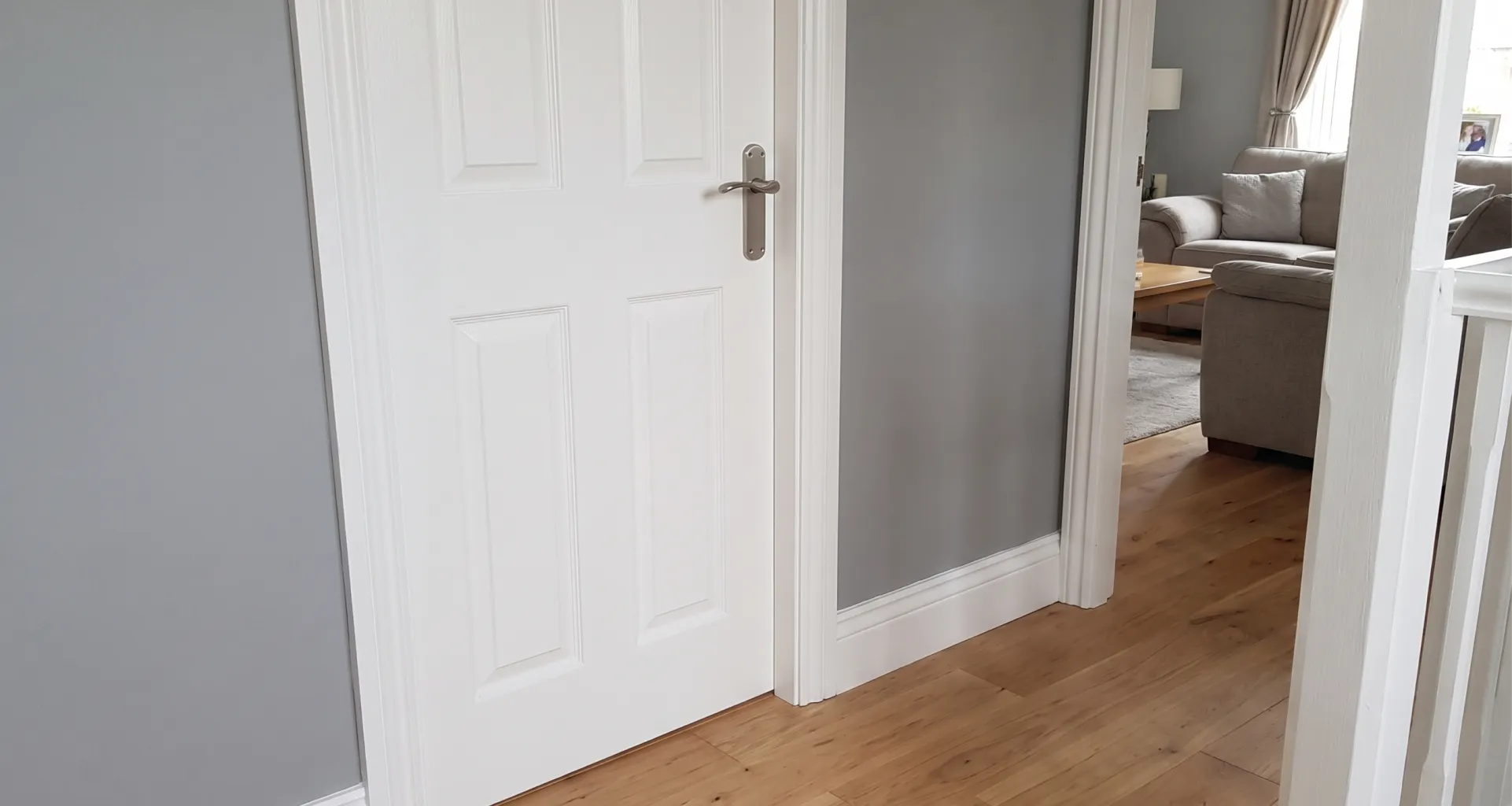 A close-up of a clean white interior door with a silver lever handle