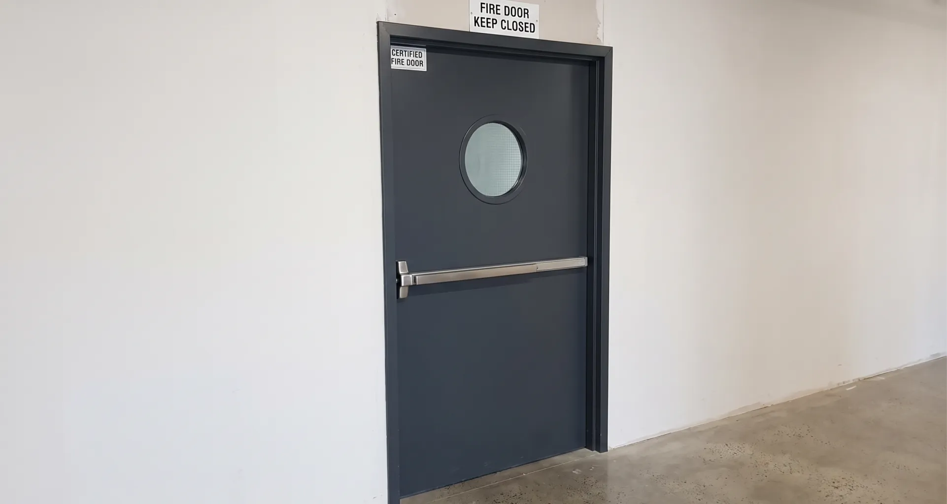 Fire-rating label on the hinge edge of a hollow metal door during inspection