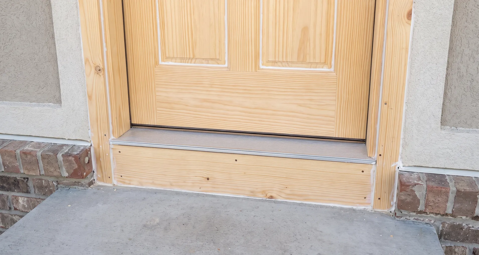 New door jamb being shimmed and levelled in a stripped door opening