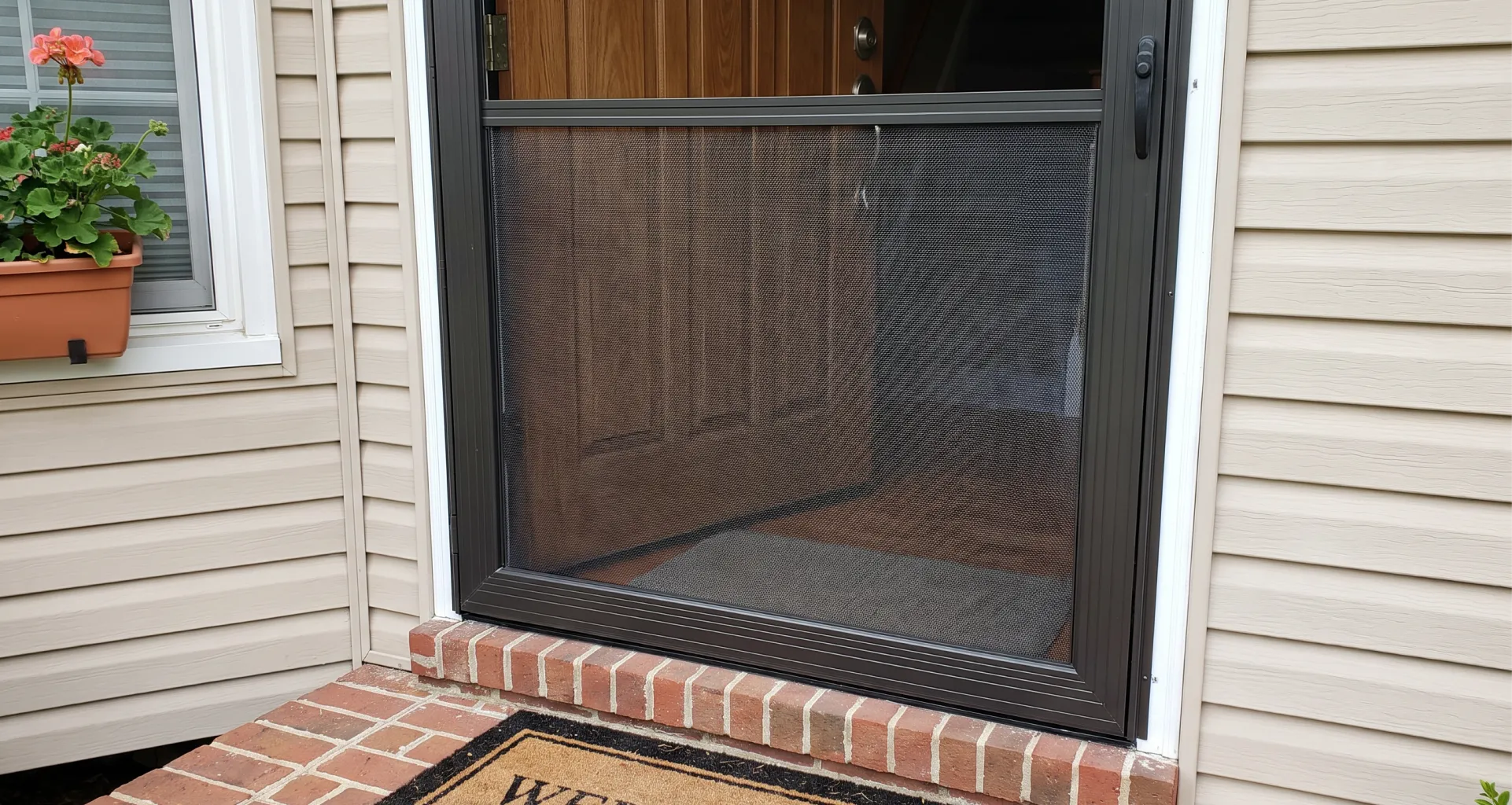 Screen mesh being rolled into an aluminum screen door frame with a spline tool